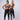 Two women wearing matching athletic outfits on a plain background