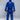 A person stands barefoot facing away, wearing the Lightweight BJJ Gi Blue with a black belt. The FUJI logo is visible on the back of both the jacket and pants. The background is plain gray.