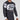 Wearing the Jiu Jitsu Script Flex Lite Long Sleeve Rashguard Black featuring Fuji and Jiu Jitsu logos on the chest and sleeves, a person stands against a plain light background.