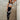 Woman wearing a black and white leopard print sports outfit against a concrete wall.